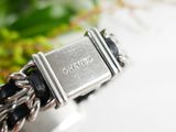 a close up of a silver bracelet with a chain around it