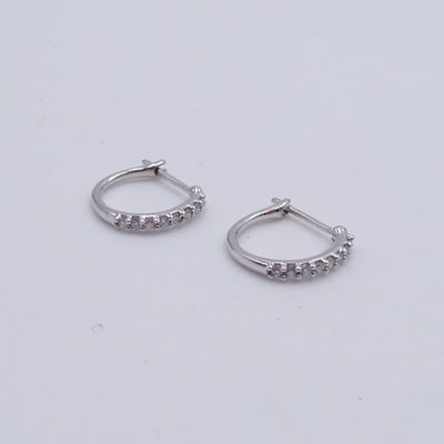 une paire de boucles d'oreilles créoles en diamant sur fond blanc