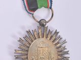 a medal with a ribbon around it on a white surface
