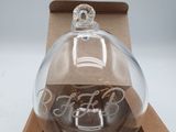 a clear glass ornament in a box on a table