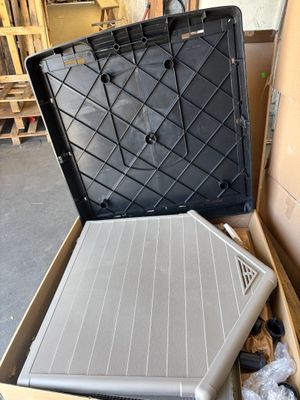 une boîte contenant un ordinateur portable, posée par terre