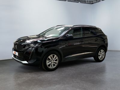Le SUV noir est garé dans une grande pièce aux murs blancs.