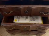 a wooden dresser with a book on top of it