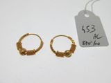 deux boucles d'oreilles en anneau dorées avec une étiquette de prix sur un fond blanc