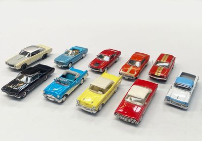 several toy cars are lined up in a row on a white surface