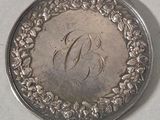 a silver coin with the letter d on it