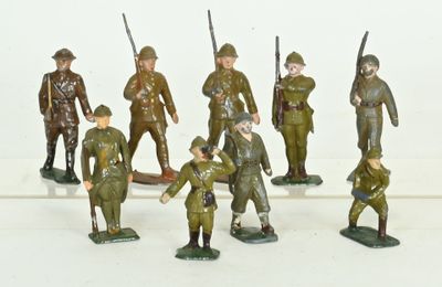 many figurines of men in military uniforms on a white surface
