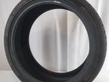 a close up of a tire on a white surface with a curtain in the background