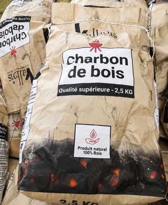 plusieurs sacs de charbon de bois sont empilés les uns sur les autres