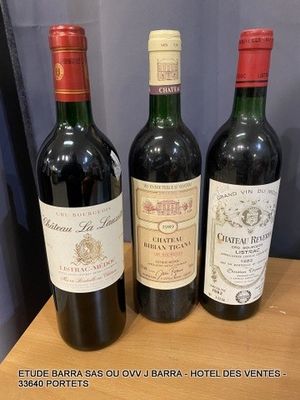 three bottles of wine are sitting on a table in front of a blue curtain
