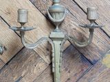 a wall mounted candle holder with two candles on it
