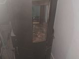 a black stove in the corner of a room next to a wall