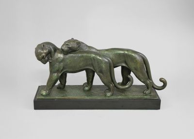 une statue en bronze représentant un lion et une lionne sur un socle