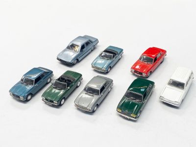 plusieurs petites voitures sont alignées sur une surface blanche