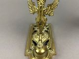 an antique brass clock with a bird on top of it