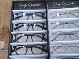 several pairs of glasses are in a display case on a table