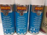 three spray cans of hycote paint sitting on a table