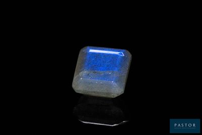 a close up of a blue and white stone on a black surface