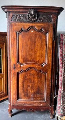 une armoire en bois posée à côté d'un lit dans une chambre