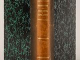 an old book sitting on top of a table next to a white wall