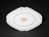 a small white bowl with a brown label on it