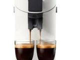un gros plan sur deux tasses de café en train d'être versées dans une machine à café