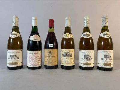 six bouteilles de vin sont alignées sur une table