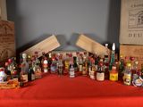 many bottles of alcohol sitting on a table with a red table cloth