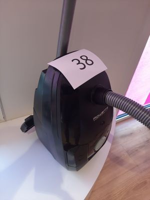 un aspirateur noir et blanc posé sur une table, sur laquelle est collé un autocollant