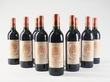 six bottles of red wine lined up in a row on a white surface