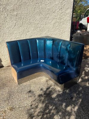 a blue bench that is outside on the sidewalk