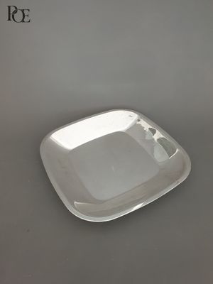 une assiette en argent posée sur une table grise, sur fond blanc