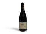 une bouteille de vin posée sur une surface blanche