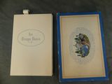 an open book sitting on top of a table next to a blue box