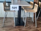 une table et des chaises dans une pièce où est affichée une étiquette de prix