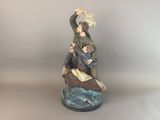 an image of a figurine of a man and woman in a boat