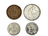 four different types of coins are shown on a white surface