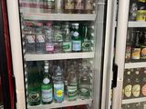 many bottles of beer in a refrigerator in a store