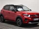the red suv is parked in a room with a checkered floor