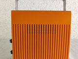 an orange radio sitting on top of a table next to a white wall