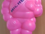 un ballon rose en forme d'homme sur lequel est inscrit un nom