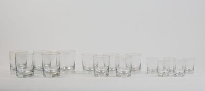 six shot glasses lined up in a row on a white surface