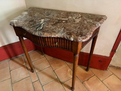 une table au plateau en marbre, dans un coin de la pièce