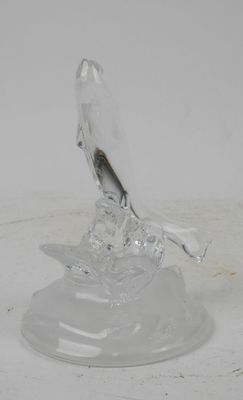 a glass sculpture of a bird sitting on top of a base