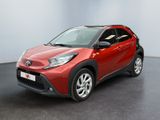 Une Toyota C-HR rouge est garée dans une grande pièce
