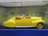 une petite voiture jaune avec un chien à l'intérieur