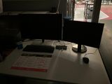 un bureau équipé de deux écrans et d'un clavier
