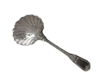 une cuillère en argent ornée d'une feuille, posée sur un fond blanc