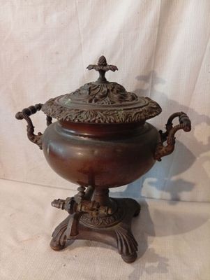 une urne antique en bronze avec un couvercle, posée sur un socle