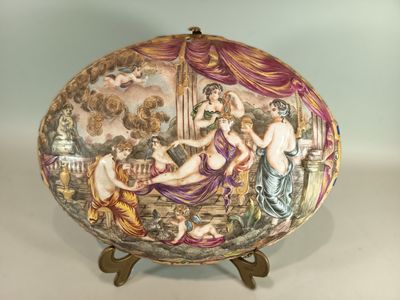a decorative plate with a painting on it on a stand